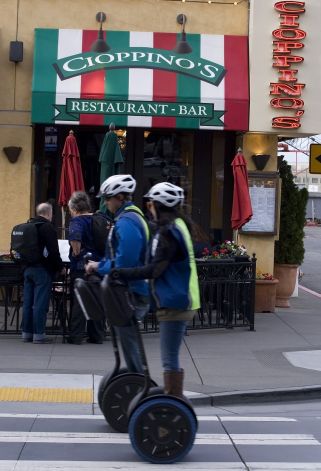 Visitors riding Segways make their way past Cioppino's restaurant, which has become a Fisherman's Wharf mainstay. Photo: Andre Zandona, The Chronicle
